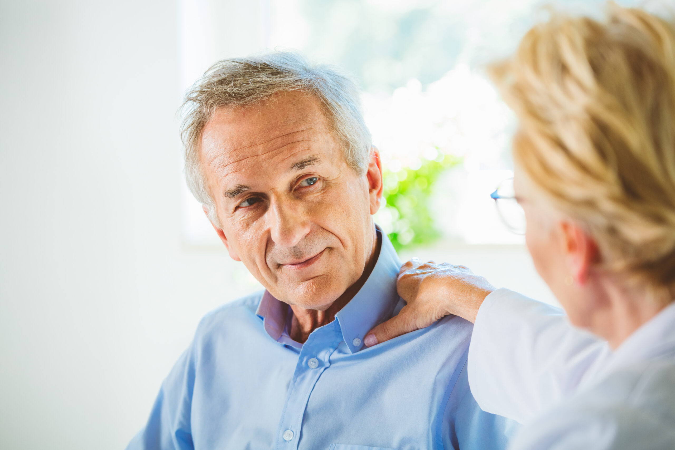 Doctor consoling senior male patient
